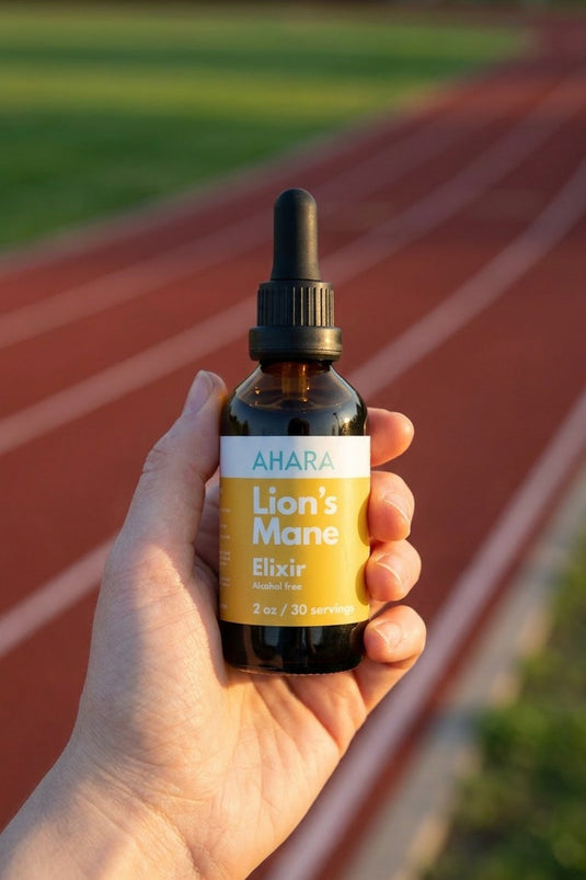 Holding the AHARA Lion's Mane Elixir outdoors