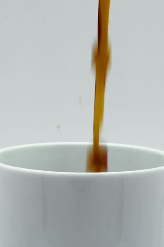 Coffee pouring into a clean white mug on a bright background